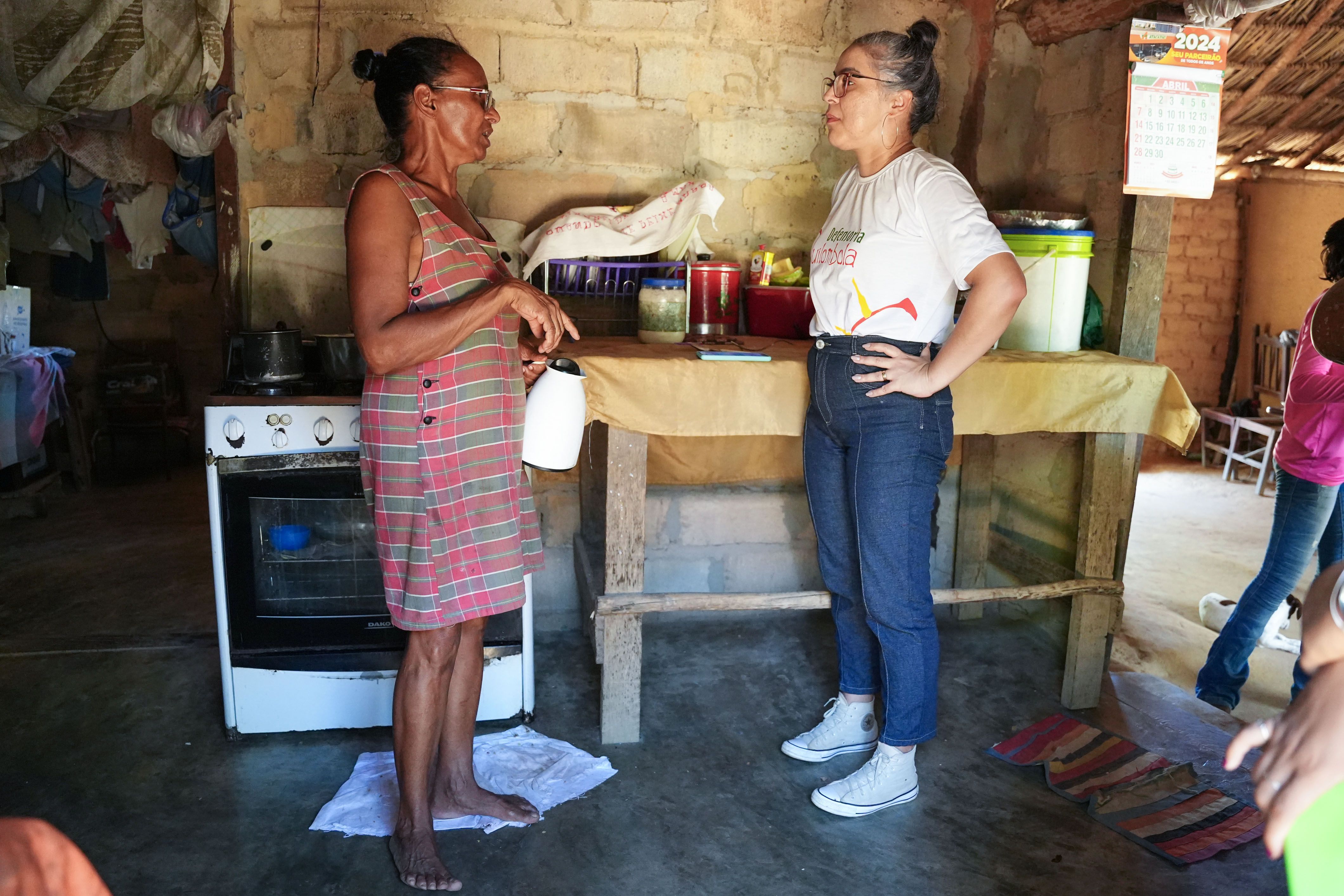Defensa pública Kênia Pimenta em conversa com uma das moradoras visitadas