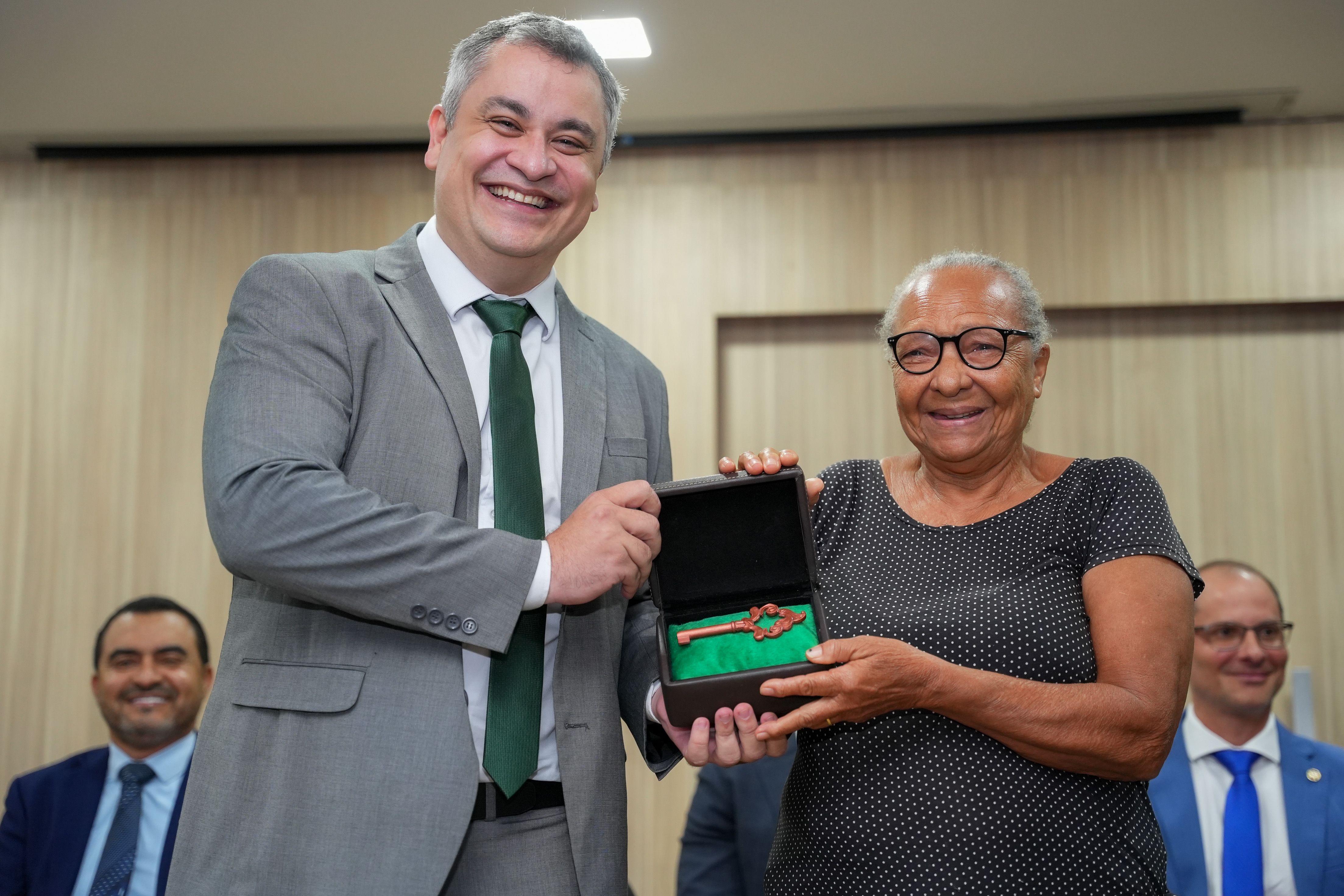 Assistida Elizabeth Silva entrega uma chave a Pedro Alexandre a porta que se abre nos lares de tantas famílias que encontram na Defensoria Pública o apoio