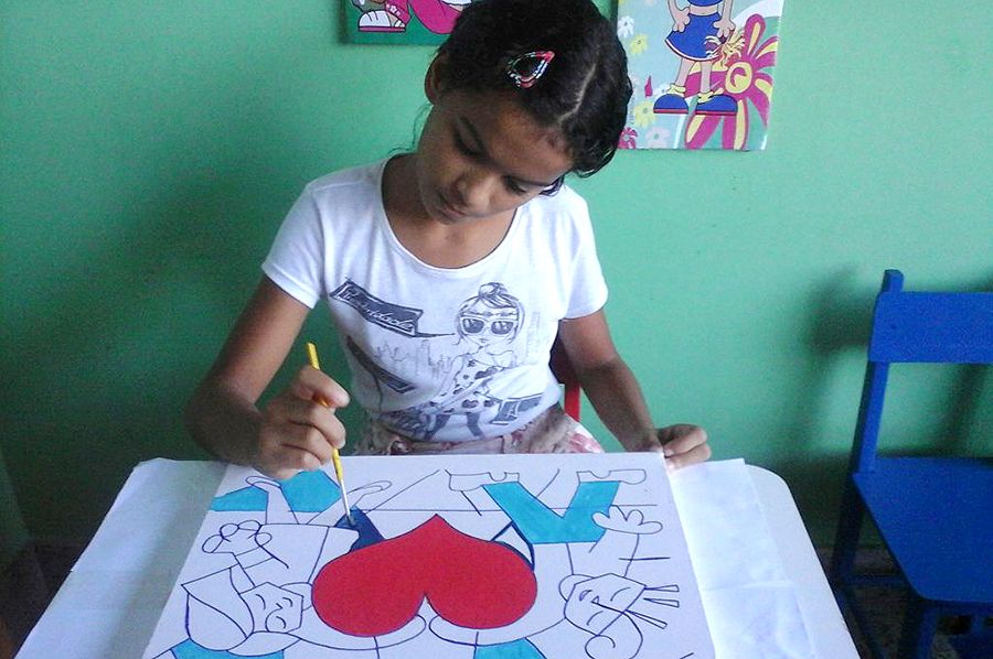 Criança filha de assistido da DPE durante pintura em tela