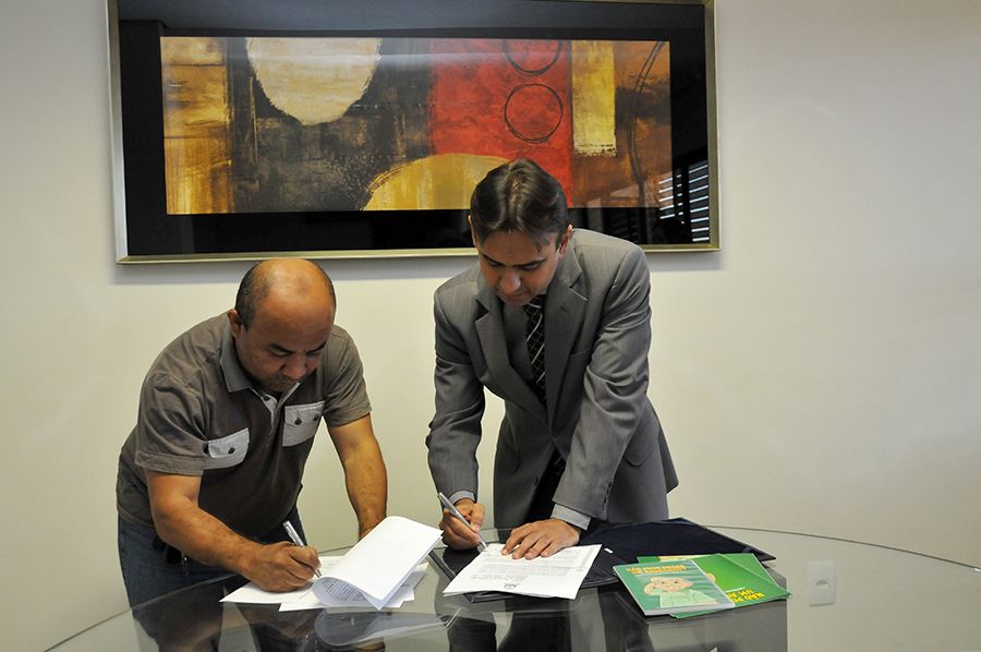 Defensor público geral, Marlon Amorim,  e o  presidente da Abraço-TO, durante assinatura