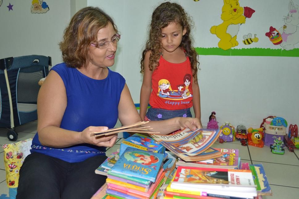 Doadora Márcia Leão conta história à Assistida da Brinquedoteca