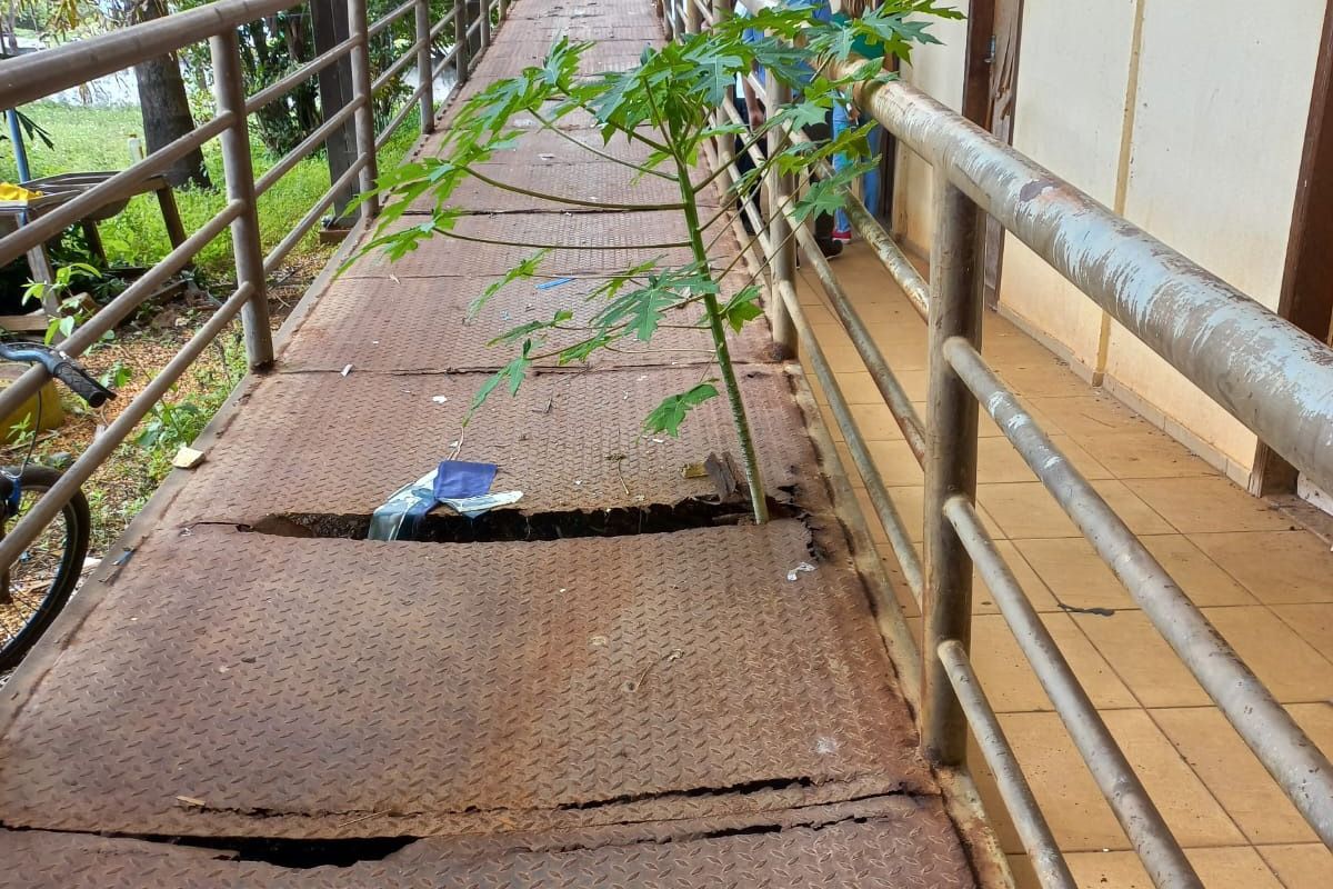 Rampa de acesso aos andares do prédio com buracos e totalmente corroída pela ferrugem