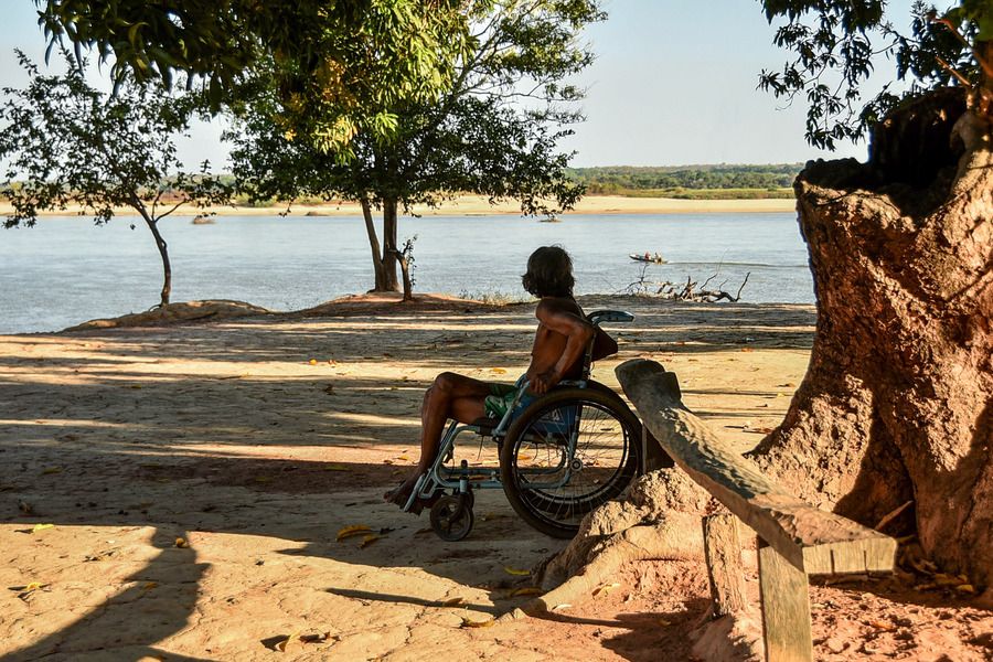 Da Aldeia Santa Isabel, indígena observa canoa indo ao longe, no Rio Araguaia, em uma cena que nos chama a atenção sobre acessibilidade também nas aldeias