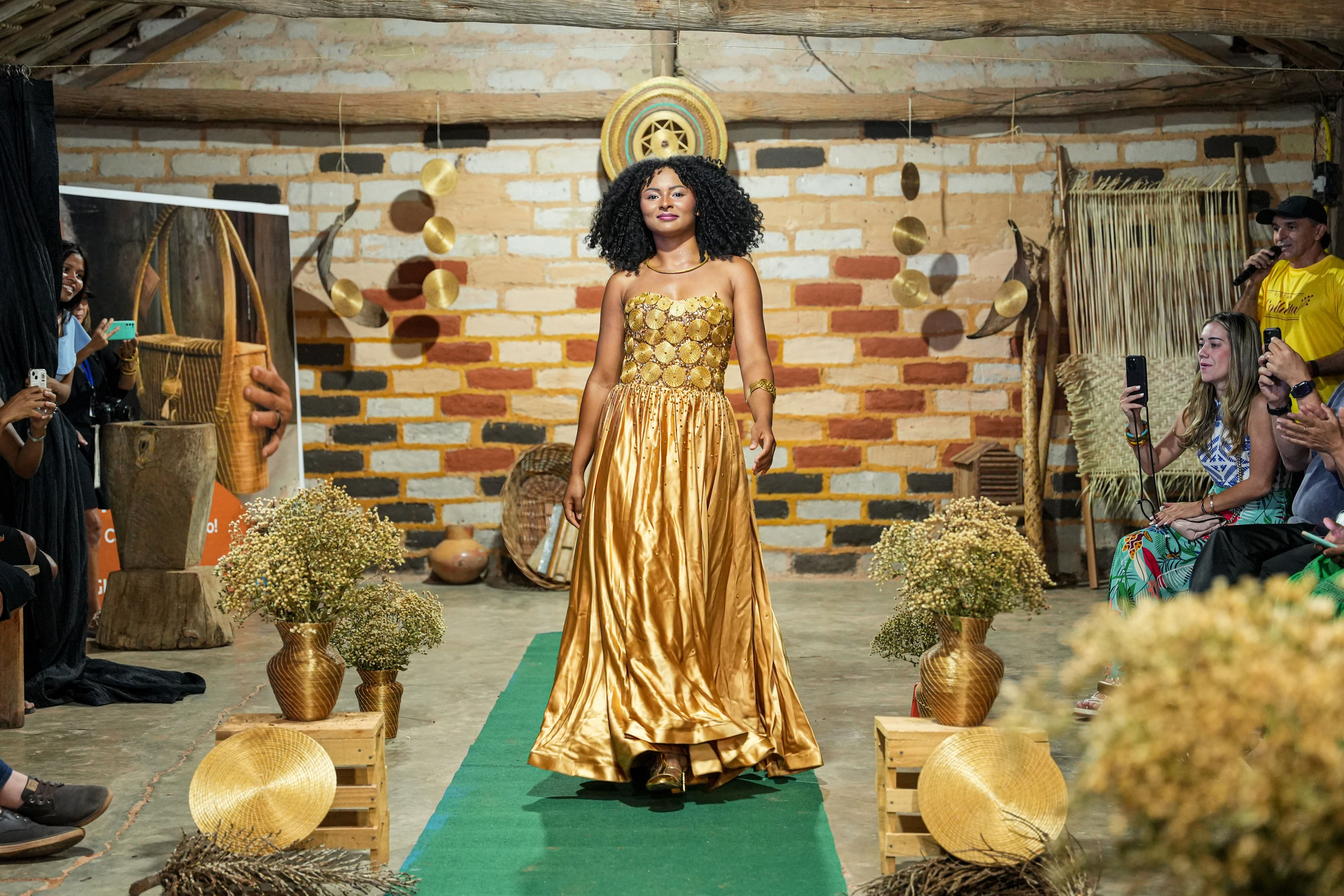 Quilombola Núbia Matos exibe um vestido de capim dourado, confeccionado pelo estilista Luiz Fernando